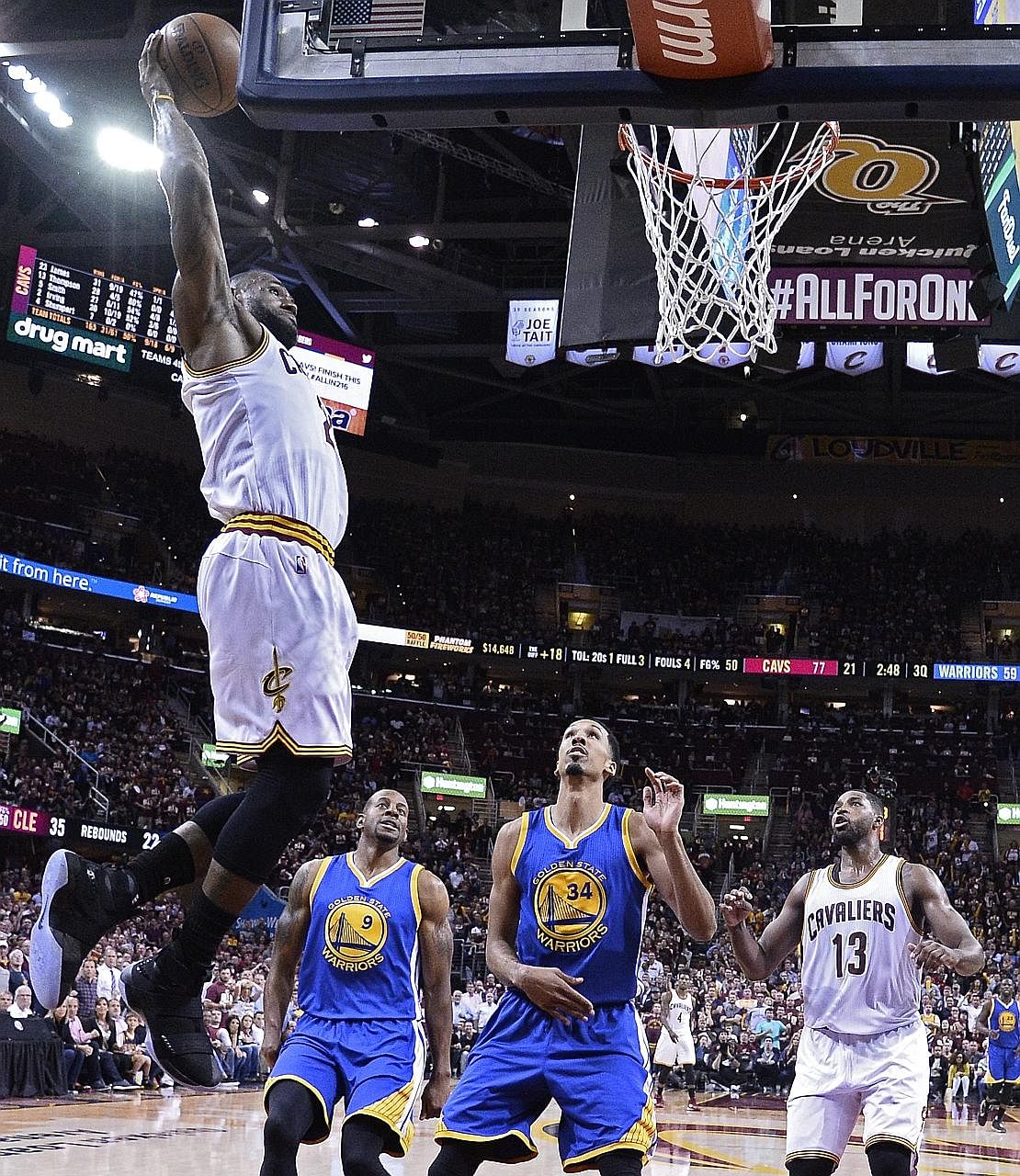 Cleveland's LeBron James dunks as Golden State's Andre Iguodala (centre) and Shaun Livingston look on. James set the tone for a 120-90 win to cut the Warriors' lead in the Finals to 2-1.
