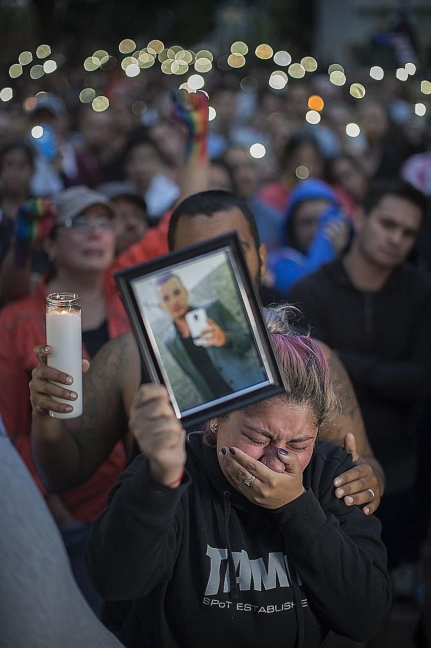 Ms Alison Cosio displaying a photo of her friend Christopher Sanfeliz during a vigil on Monday in Los Angeles. He was among those killed at the Pulse nightclub in Orlando on Sunday in the worst mass shooting in US history.