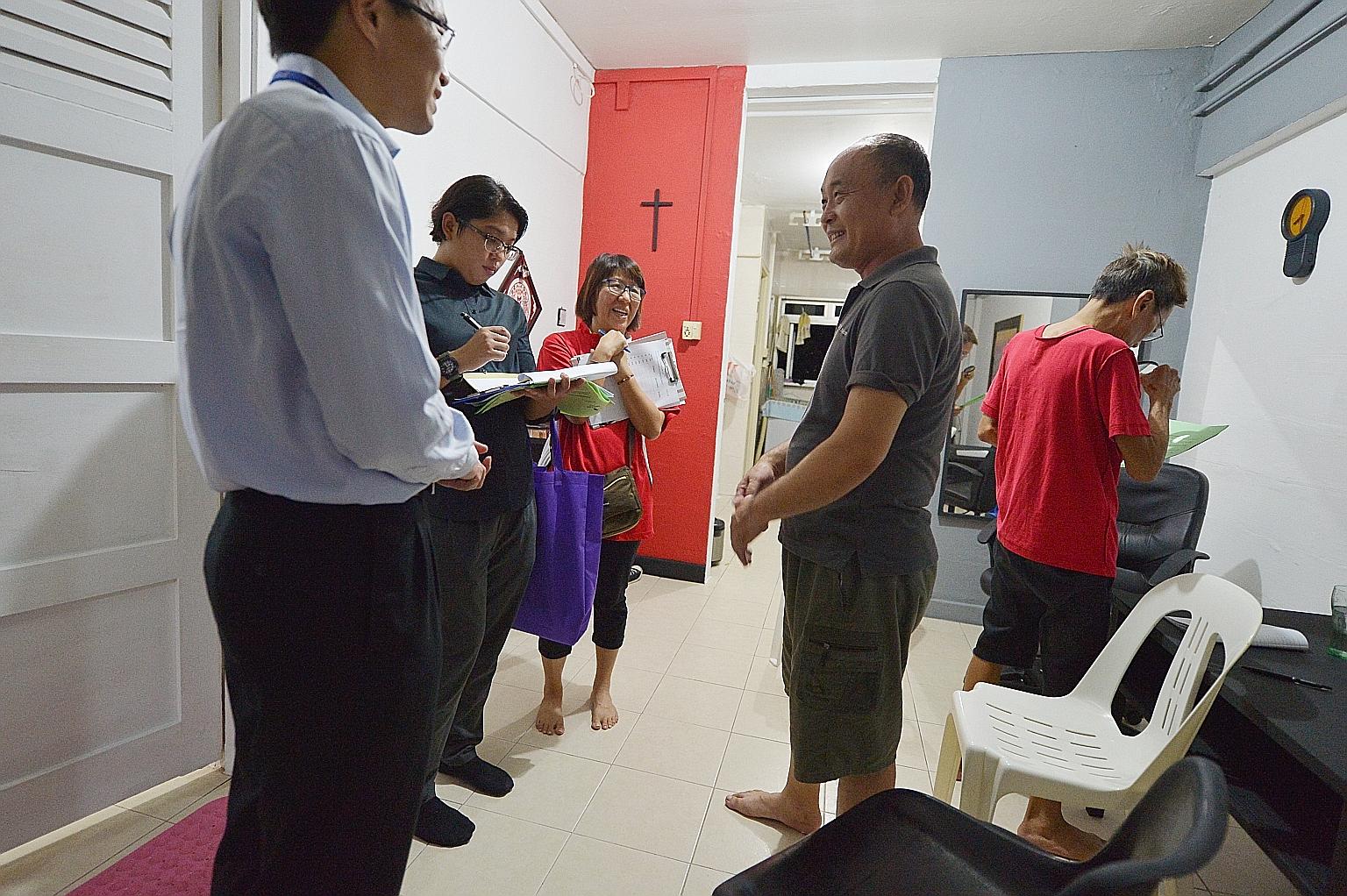 Residents' committee members and Health Ministry officials visiting Mr Bu Qing Liang (in grey), 48, at his home in Block 203, Ang Mo Kio Avenue 3, yesterday. All residents of the block are being urged to go for a free TB screening that will be provid
