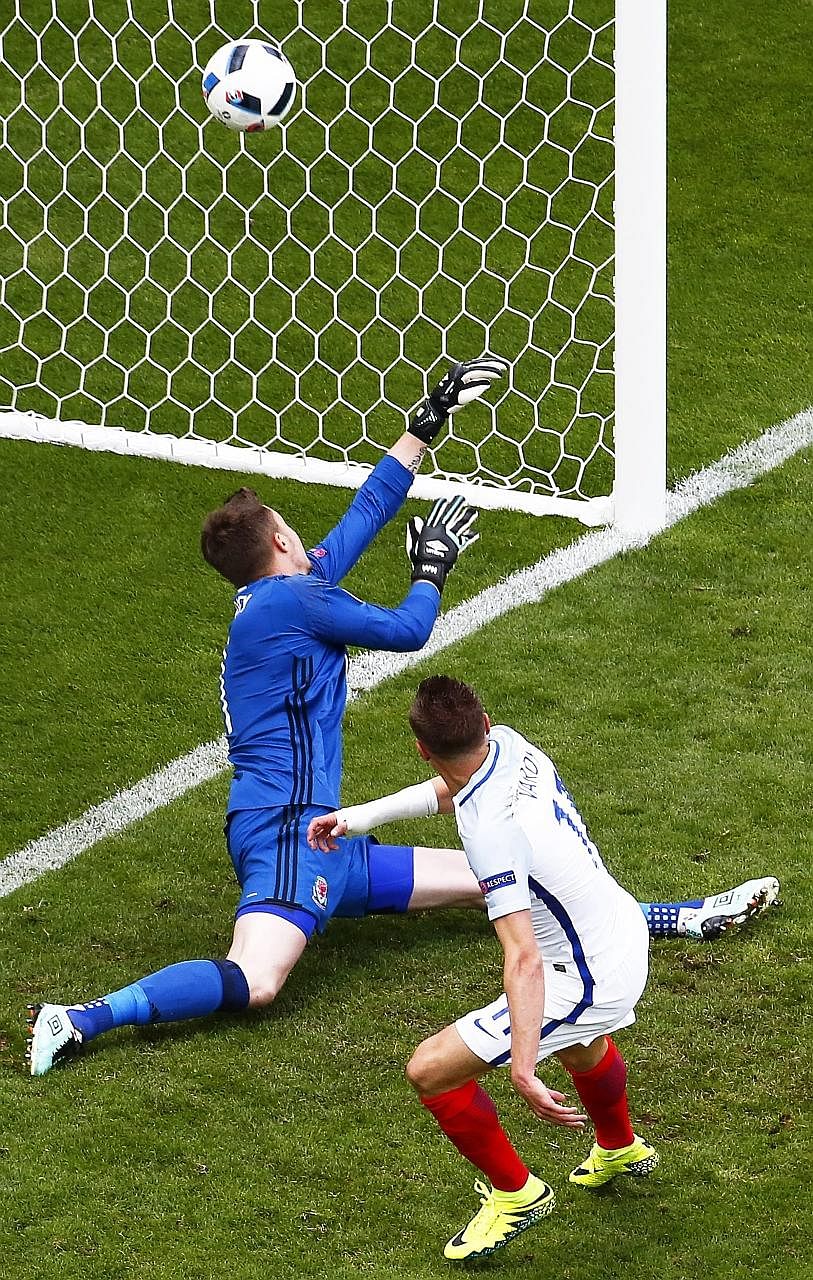 England's Jamie Vardy scoring the equaliser past Wales goalkeeper Wayne Hennessey after coming on as a second-half substitute. His fellow replacement Daniel Sturridge later scored an injury-time winner to send England to the top of Group B.