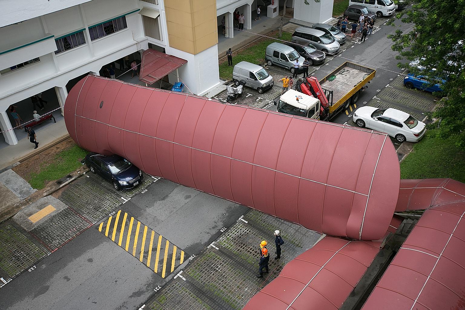 A car was crushed not by a falling tree, but by a walkway shelter at a carpark in Bukit Batok West Avenue 6 yesterday morning. The shelter came crashing down after it was struck by a lorry. The driver allegedly forgot to lower the lorry's crane, whic