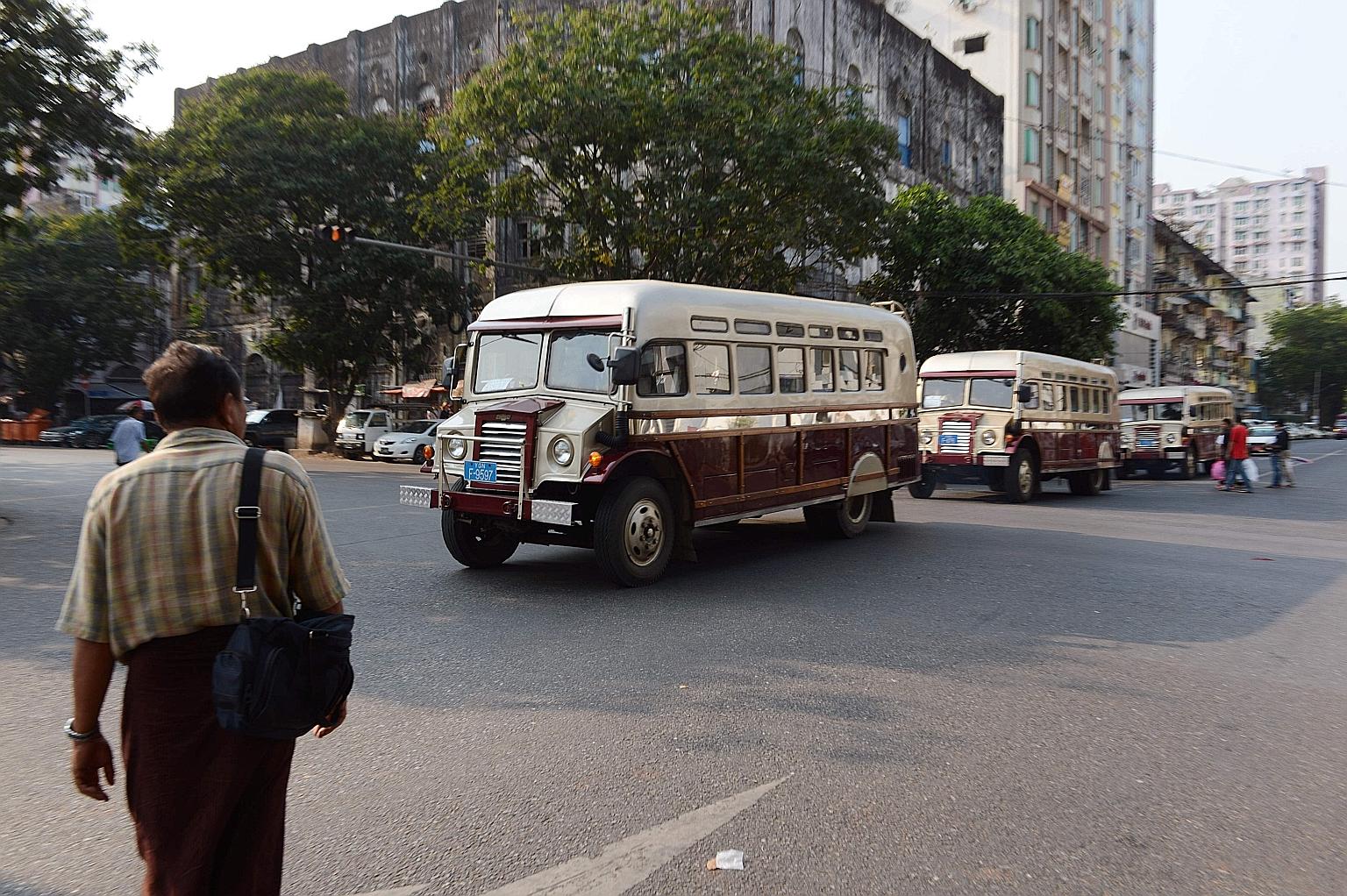 Period buses ferrying tourists around Yangon. By easing visa requirements for foreign travellers, Myanmar hopes to increase visitor arrivals and boost its tourism industry.