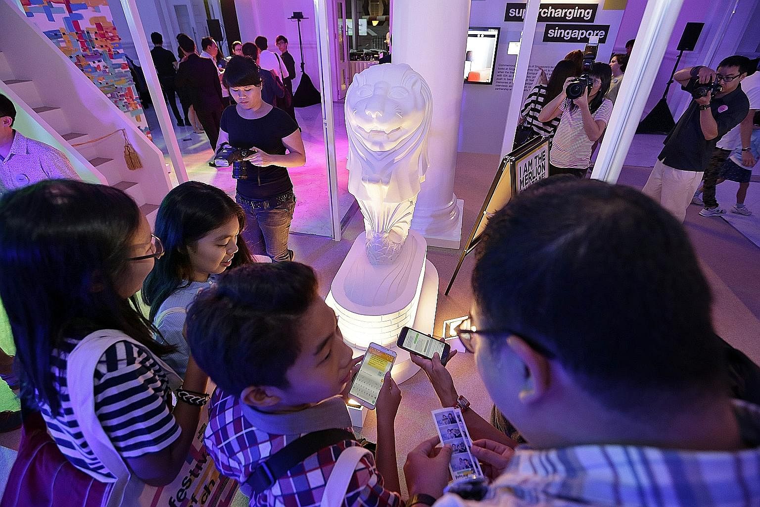 Visitors at the Festival of Tech trying to chat with a mini Merlion through mobile texting last October. The festival was organised in celebration of Singapore's Golden Jubilee, and marks the country's efforts to become a smart nation. An exhibition 