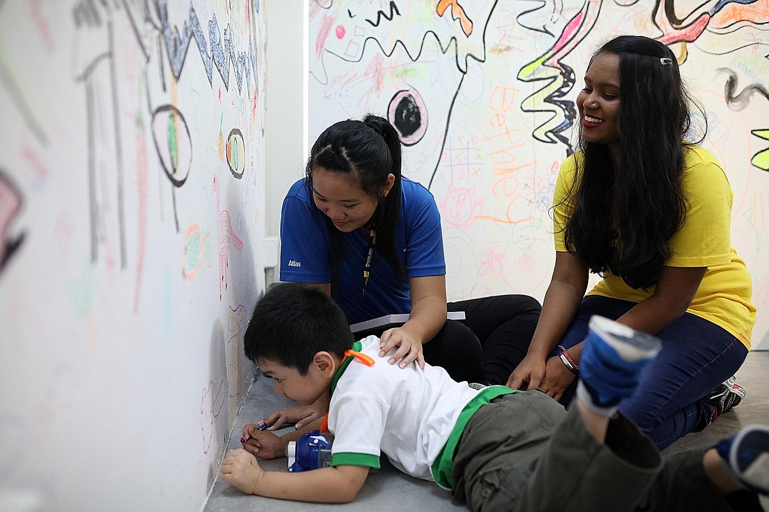 Ping Yi Secondary School student Vanessa Lian tries her hand at being a pre-school teacher at a workshop organised by Ngee Ann Polytechnic yesterday, accompanied by poly student facilitator P Usha Nantini.
