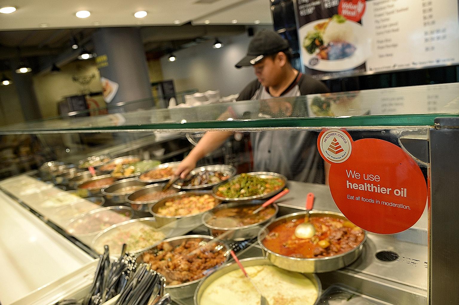 A stall at the NTUC Foodfare foodcourt in Kallang Wave Mall. Many stallholders currently rely on vegetable and palm oils but they will be required to switch to canola or olive oil in the next two to three years.
