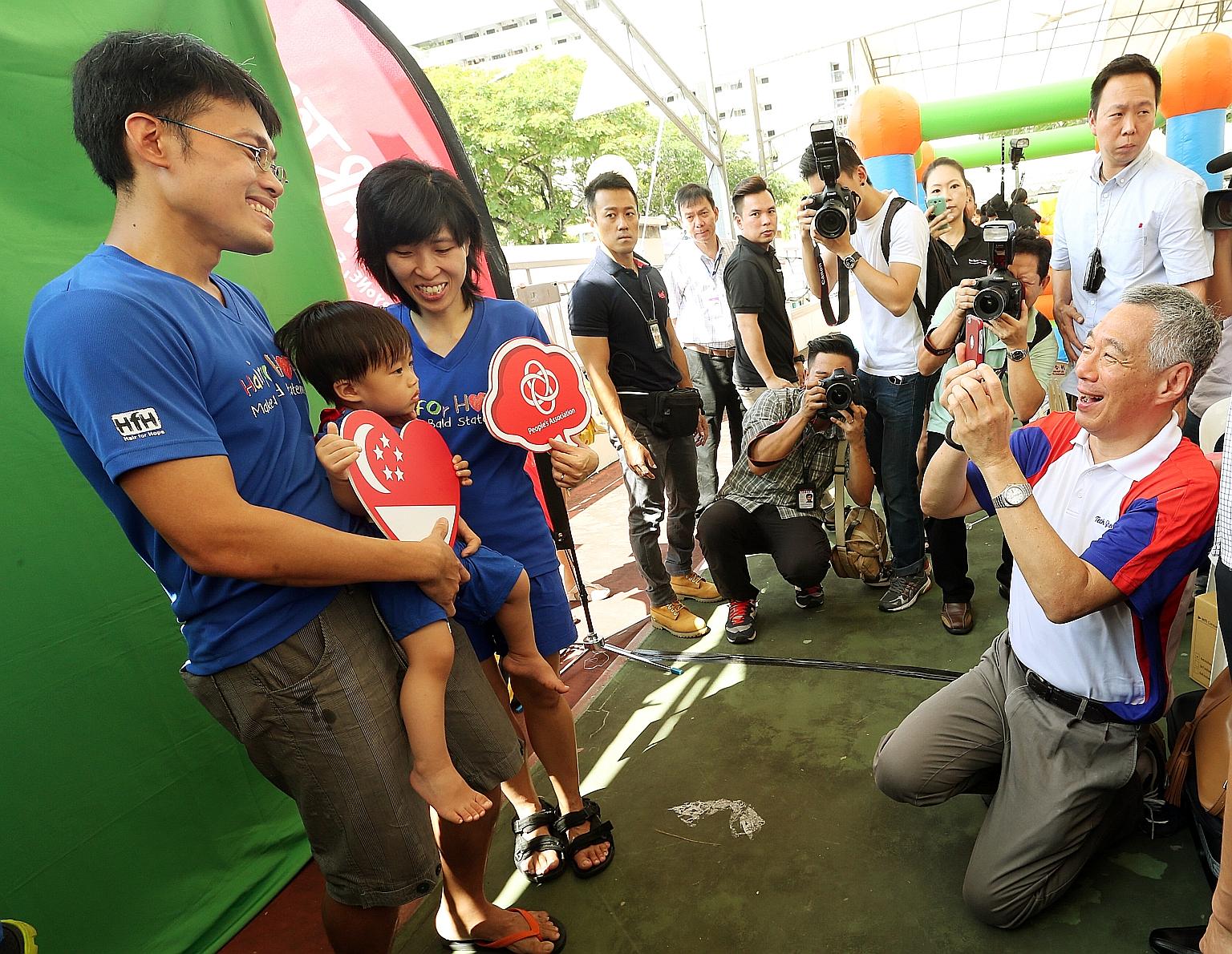 Prime Minister Lee Hsien Loong played photographer yesterday at the Teck Ghee Family Day, as he shot a family portrait for Mr Low Kang Yin, 37, his wife Ong Lizhen, 34, and their 19-month- old son Valen. Known for being a photo buff, Mr Lee took phot