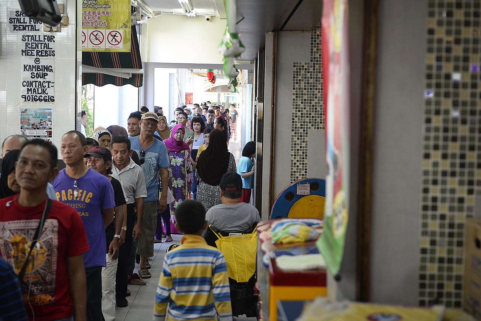 The queue for porridge at Mr Elangovan's Bedok North coffee shop yesterday. For the last decade, he has distributed porridge to hundreds of people every day during Ramadan.