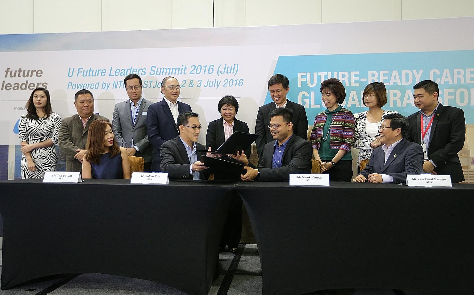 The MOU was signed by Mr Julian Tan, executive vice-president of SPH Digital, and Mr Vivek Kumar, director of U Associate and U Future Leaders, NTUC (seated, centre). It was observed by SPH CEO Alan Chan (standing, fourth from left) and NTUC secretar