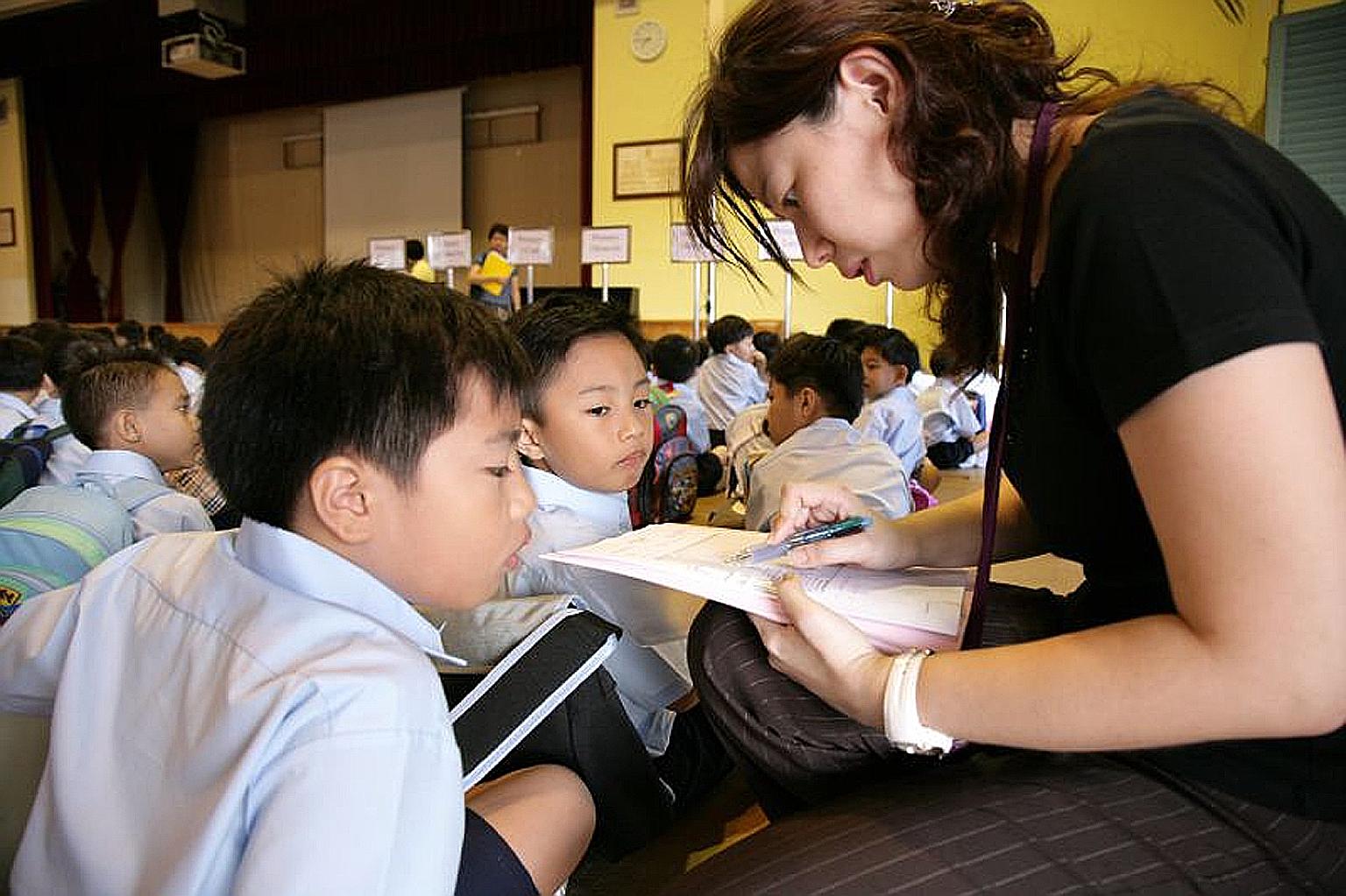 Mrs Koe, chairman of Ngee Ann Primary School's Parent Support Group, with pupils of the school. Volunteers can contribute in different ways, playing their part and balancing it with other commitments.