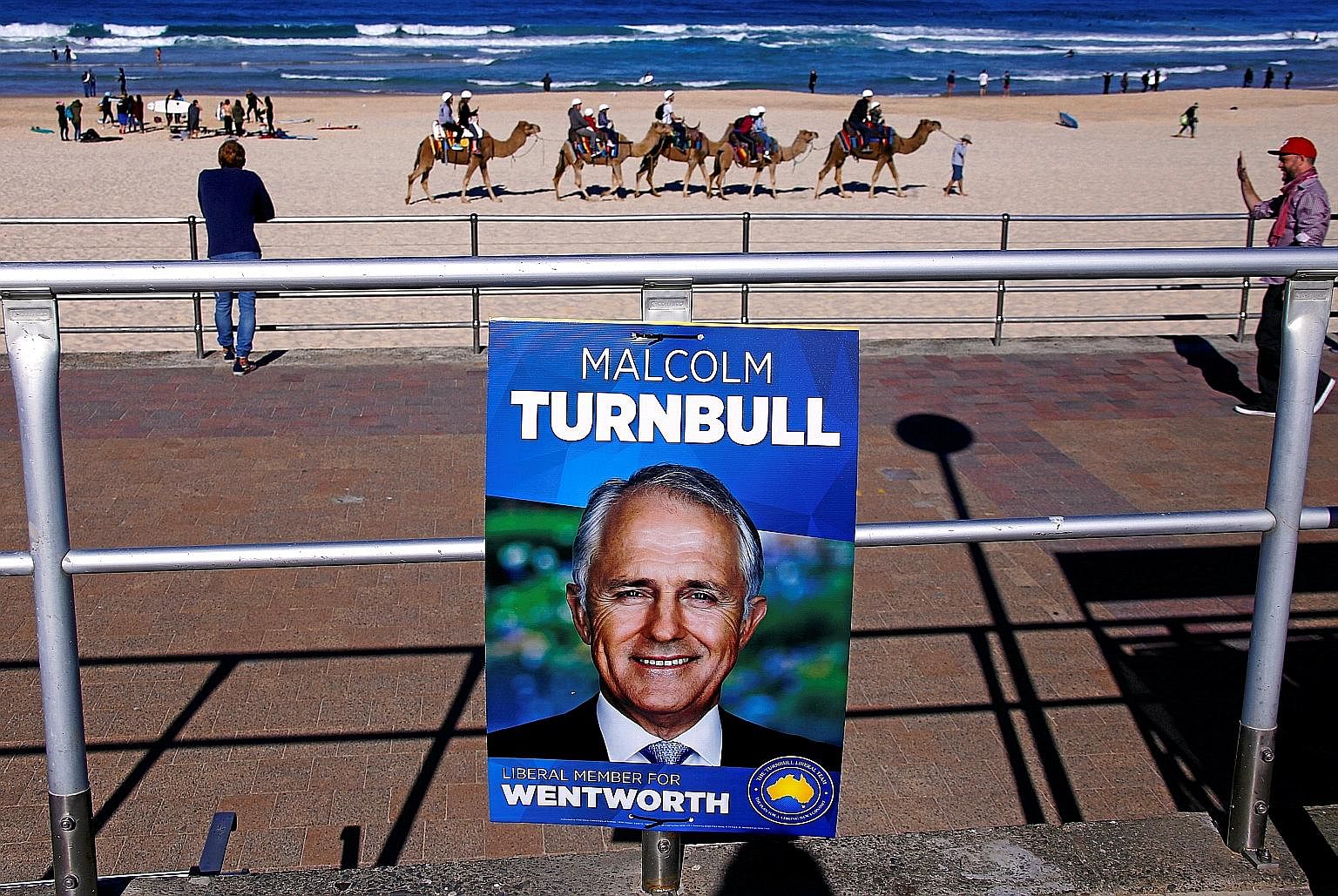 An election campaign poster of Australian Prime Minister Malcolm Turnbull against a backdrop of tourists riding camels along Bondi Beach in Sydney. Commentators have criticised Mr Turnbull's campaign, which appeared to lack energy and relied on a som