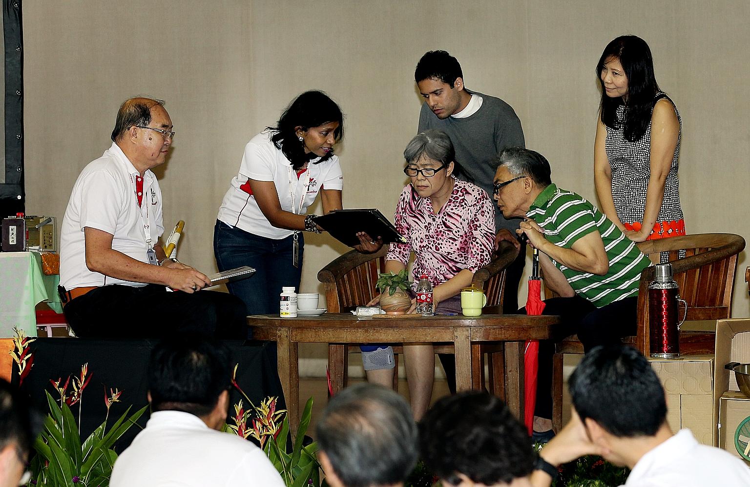 Pioneer Generation Office staff performing a skit of a home visit at a dinner for volunteers in the Ang Mo Kio and Sengkang West areas.