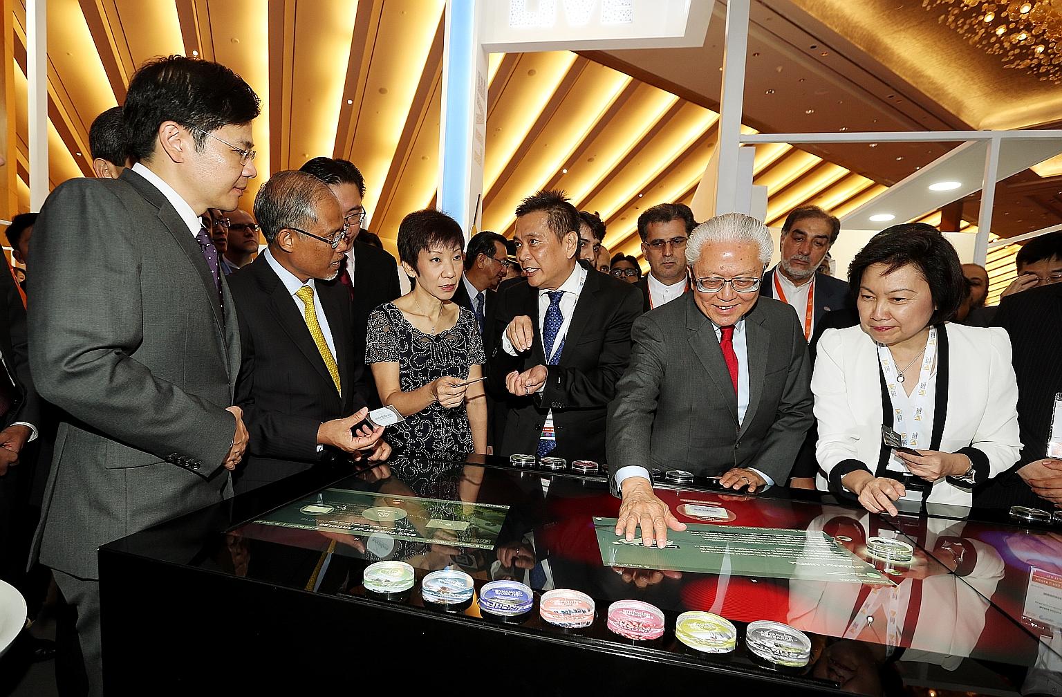 President Tan engaging with a multitouch Smart Table at the opening of the World Cities Summit, Singapore International Water Week and CleanEnviro Summit Singapore. With him are (from left) National Development Minister Lawrence Wong, Environment and