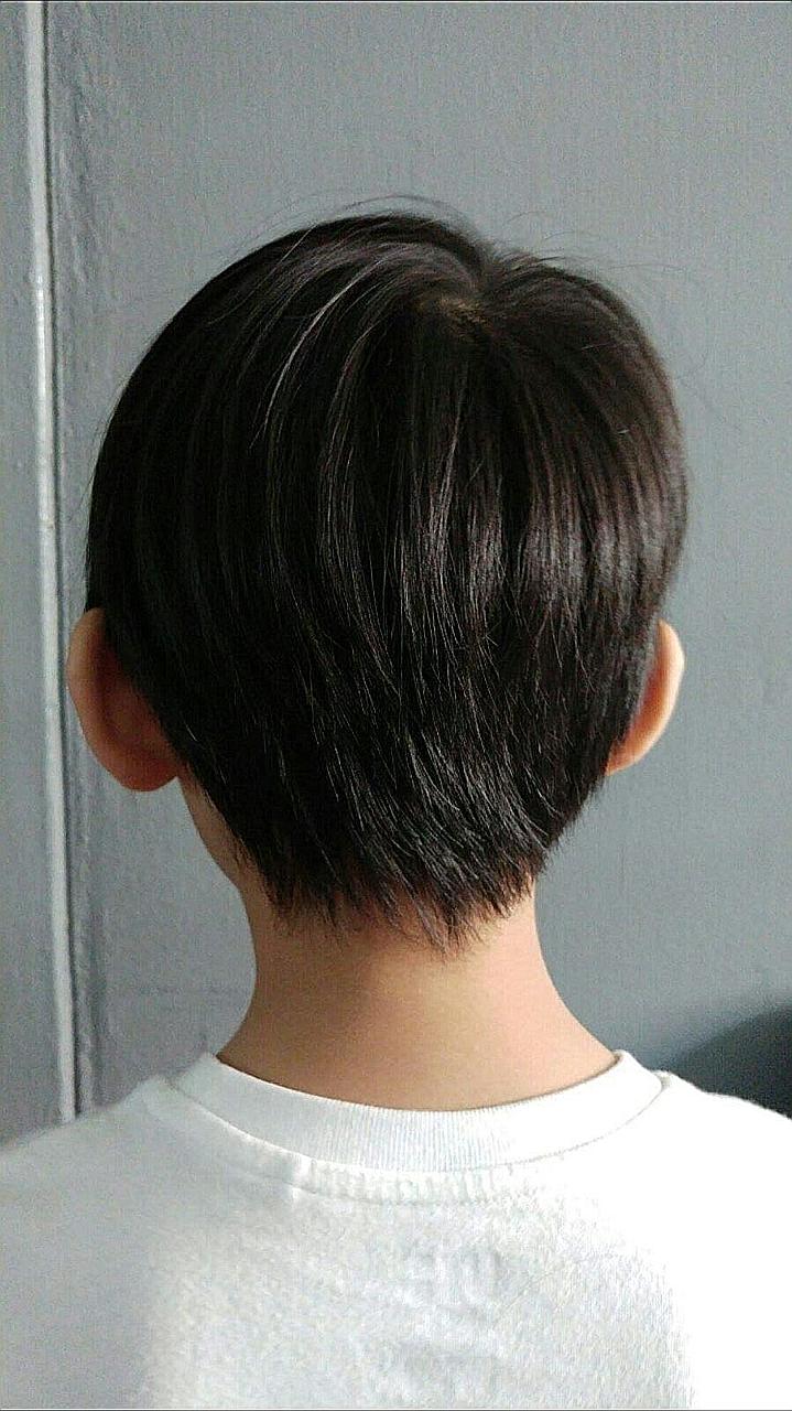 A back view of the six-year-old involved in the incident. His teacher found his hair too long and clipped it with a girl's hair clip. The incident came to light after another teacher noticed his "abnormal and despondent" behaviour, his father said in