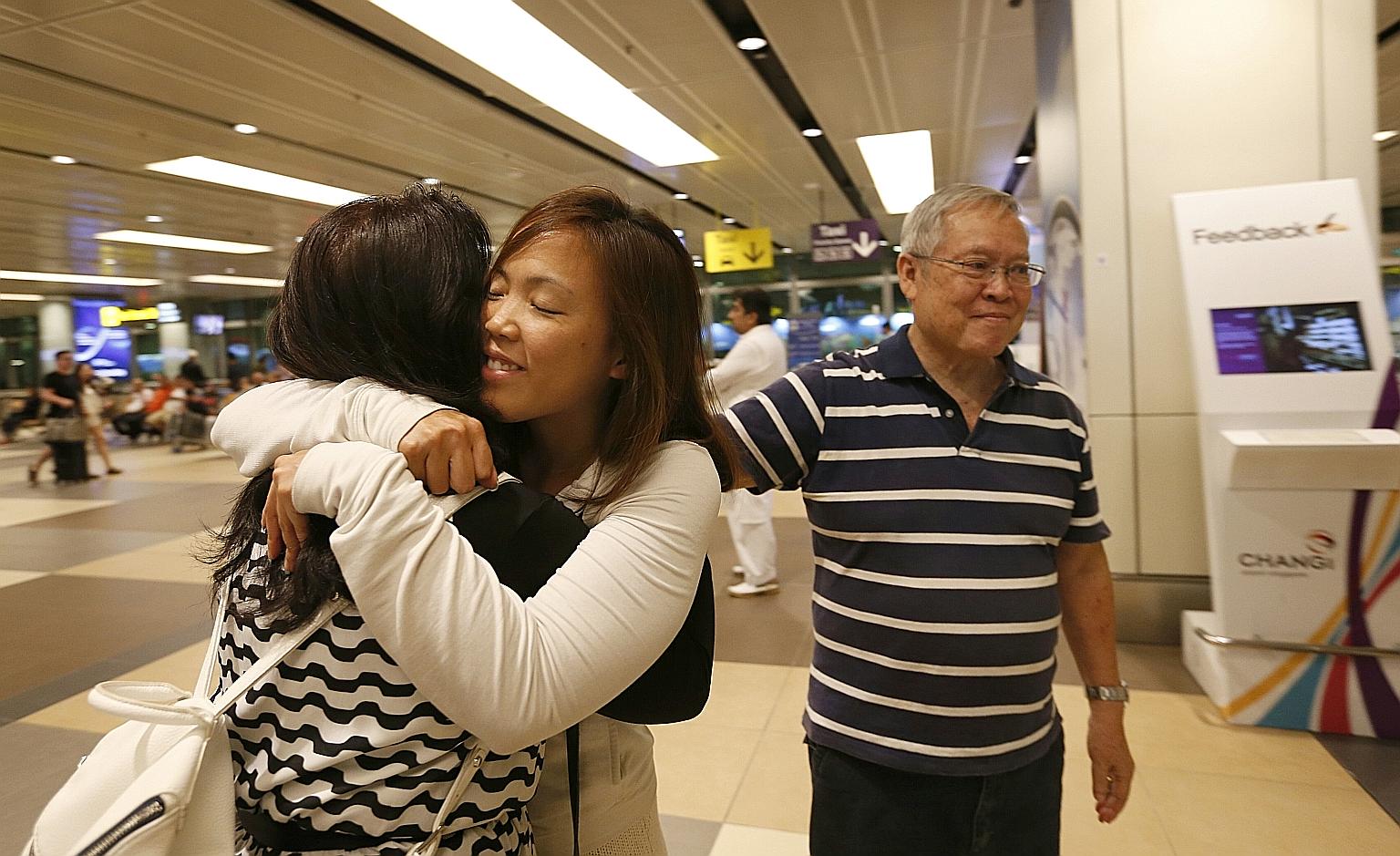 Ms Grace Feng, 33, hugging her mother, Madam Mary Lan, 66, at Changi Airport on her return from Turkey yesterday. Beside her is her father, Mr Philip Feng, 68. Several Singaporeans in Turkey resumed their journeys or arrived home last night. SEE TOP