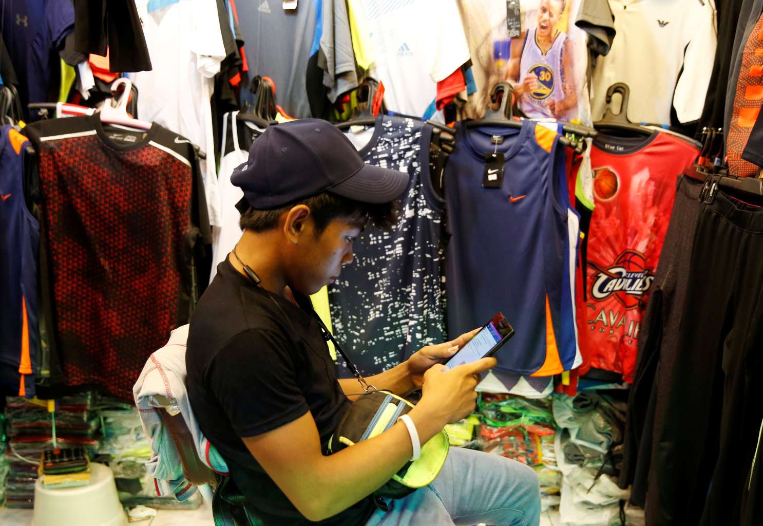 A vendor surfing the Internet on his phone in Paranaque, Metro Manila on July 7, 2016.
