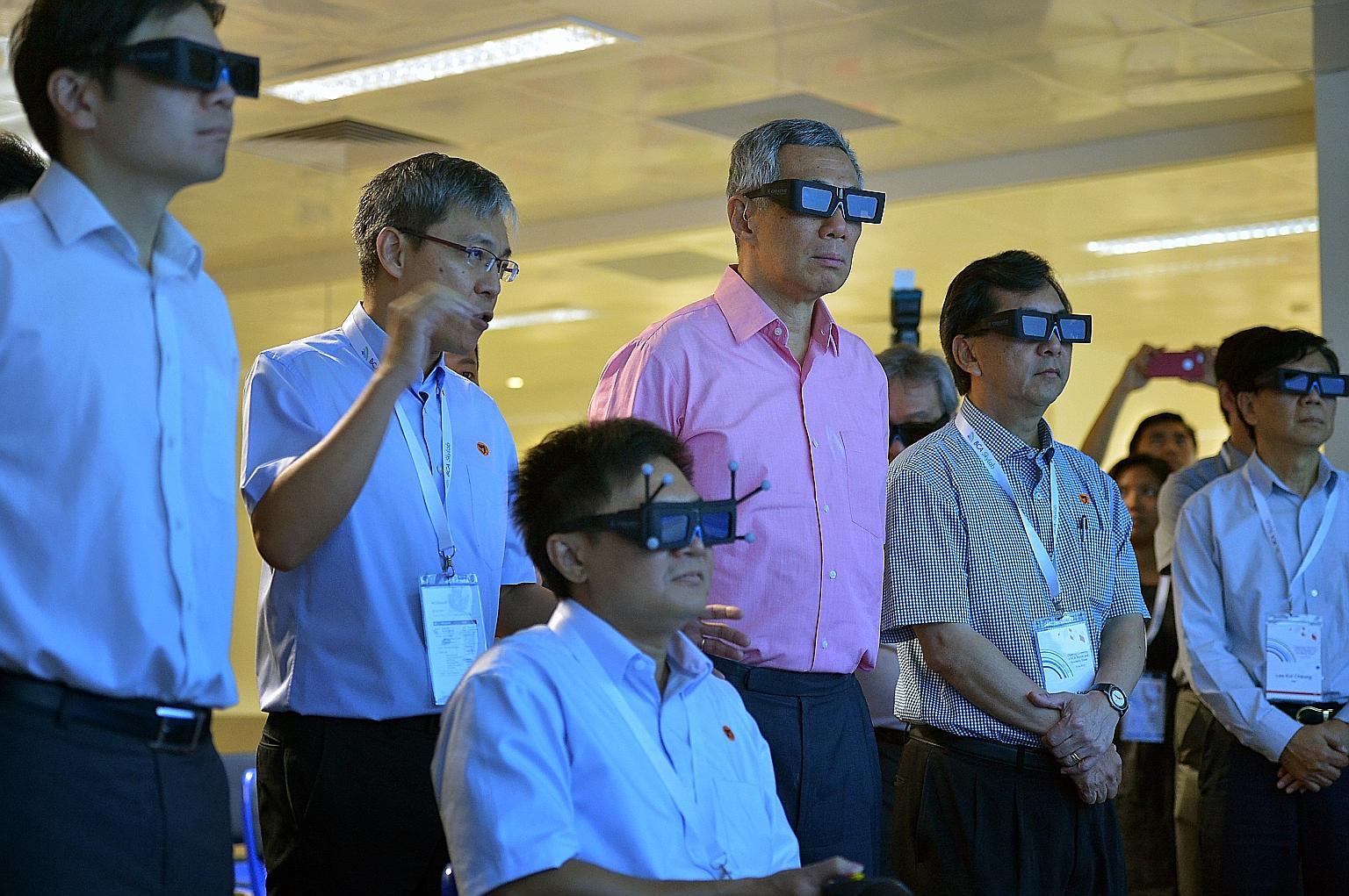PM Lee taking a virtual tour of Changi Airport's upcoming Project Jewel at the BCA's Centre for Lean and Virtual Construction yesterday with BCA chief executive John Keung (second from right) and National Development Minister Lawrence Wong (far left)