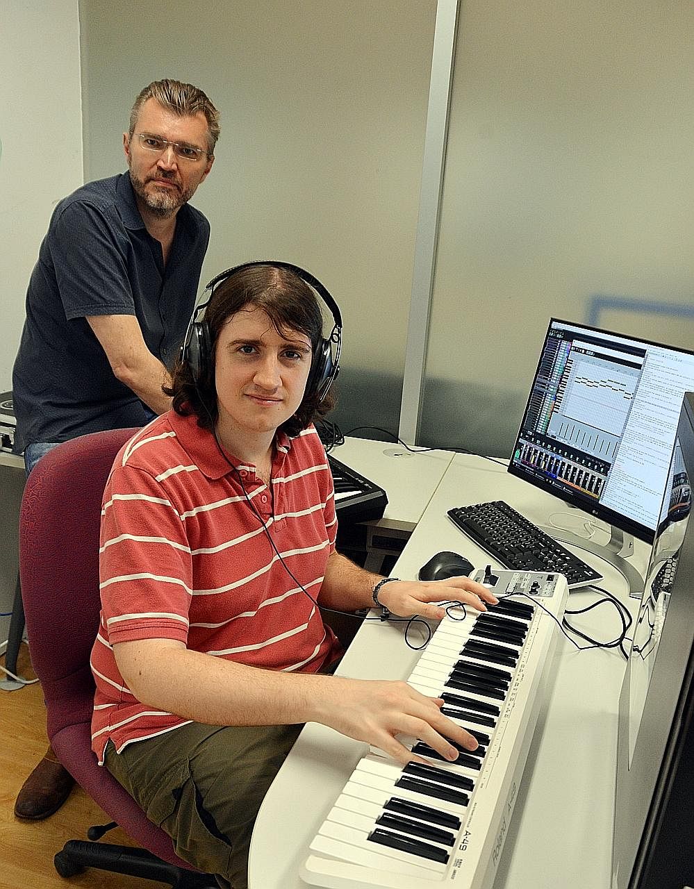 Dr Andrew Garner (in red) and Prof Vlatko Vedral at NUS' Centre for Quantum Technologies with a computer and keyboard set-up that translates quantum effects into musical sounds.