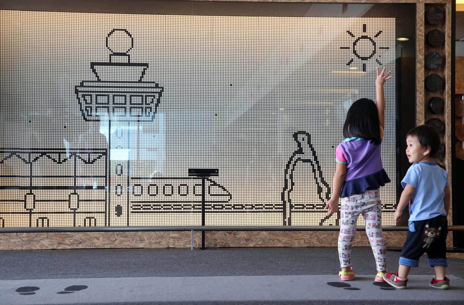 Children playing with the motion silhouette wall at Terminal 2. New attractions such as this have been installed in all three terminals.
