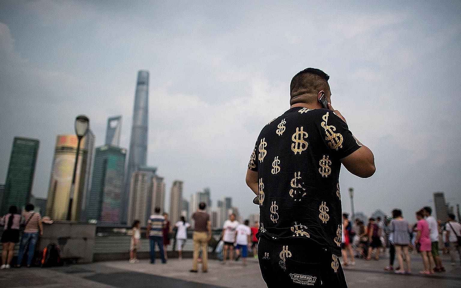 Dollars seem to be on this man's mind as he walks by Shanghai's financial district. As China's economy steadies and consumer spending increases, the prospects of many emerging markets are also improving.
