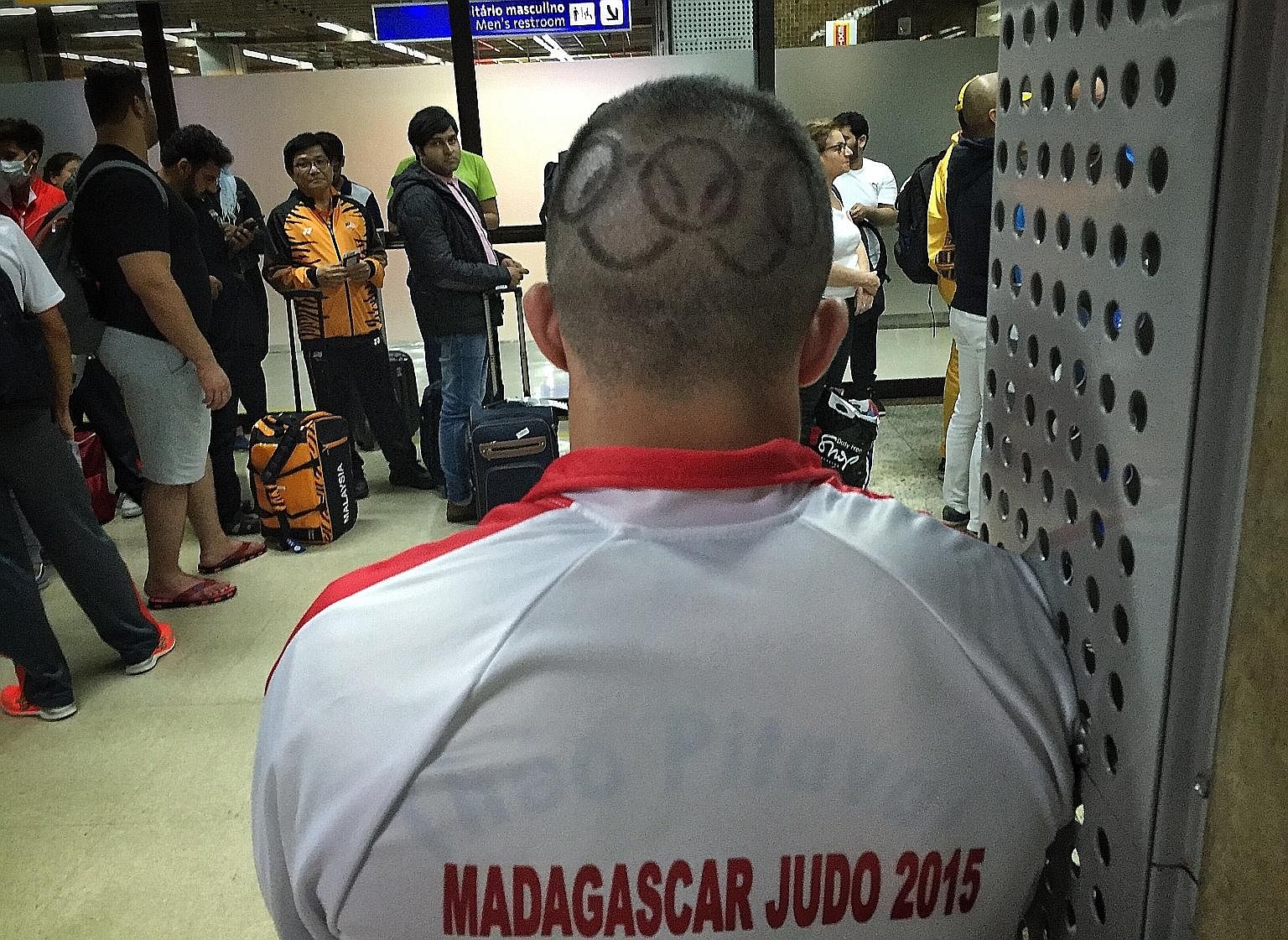 A Rio-bound Madagascar judo coach sports a haircut showing the Olympic logo as he waits in the boarding lounge at the Sao Paulo-Guarulhos International Airport.