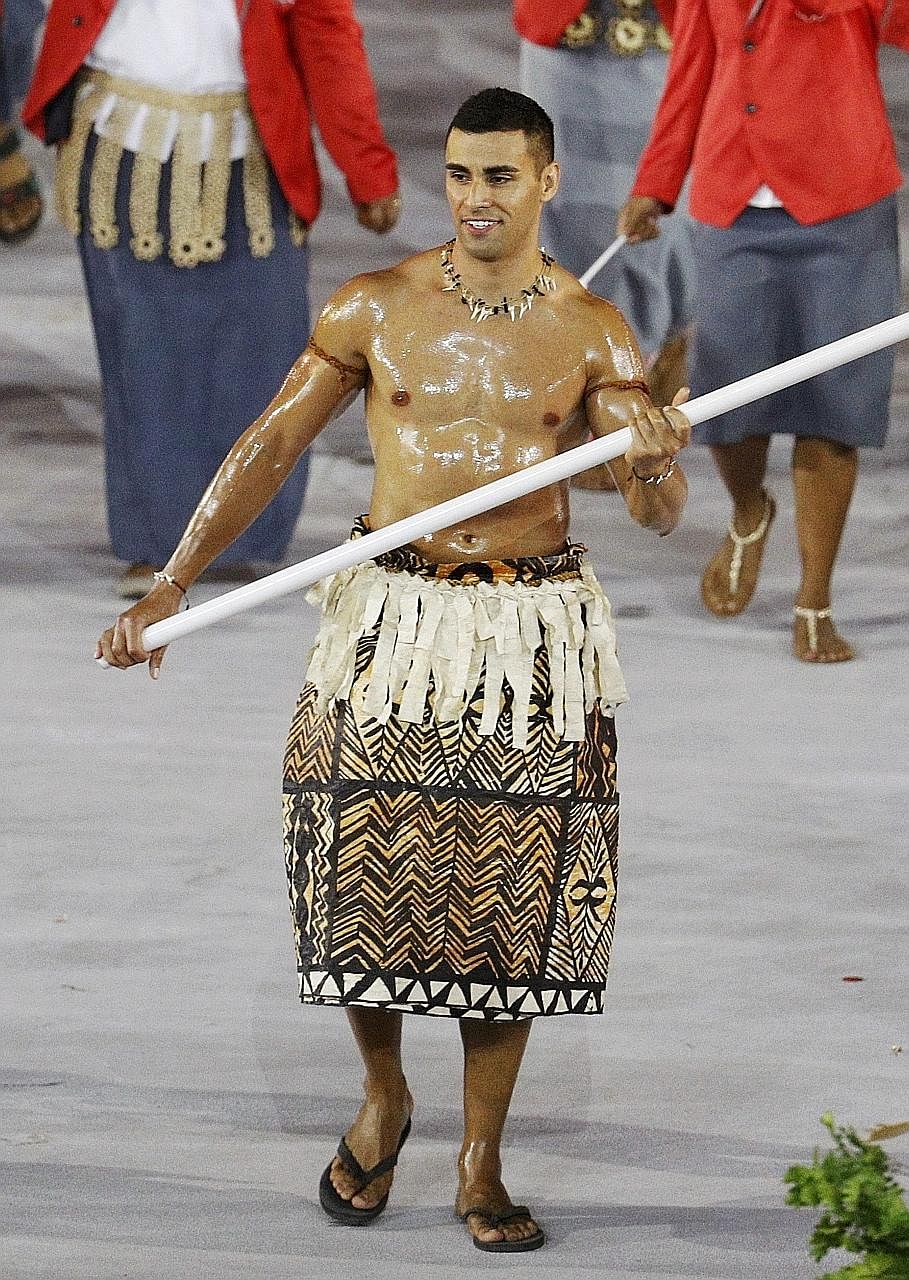 Tonga's flag bearer Pita Taufatofua (left) leading his contingent during the athletes' parade at the Olympics.