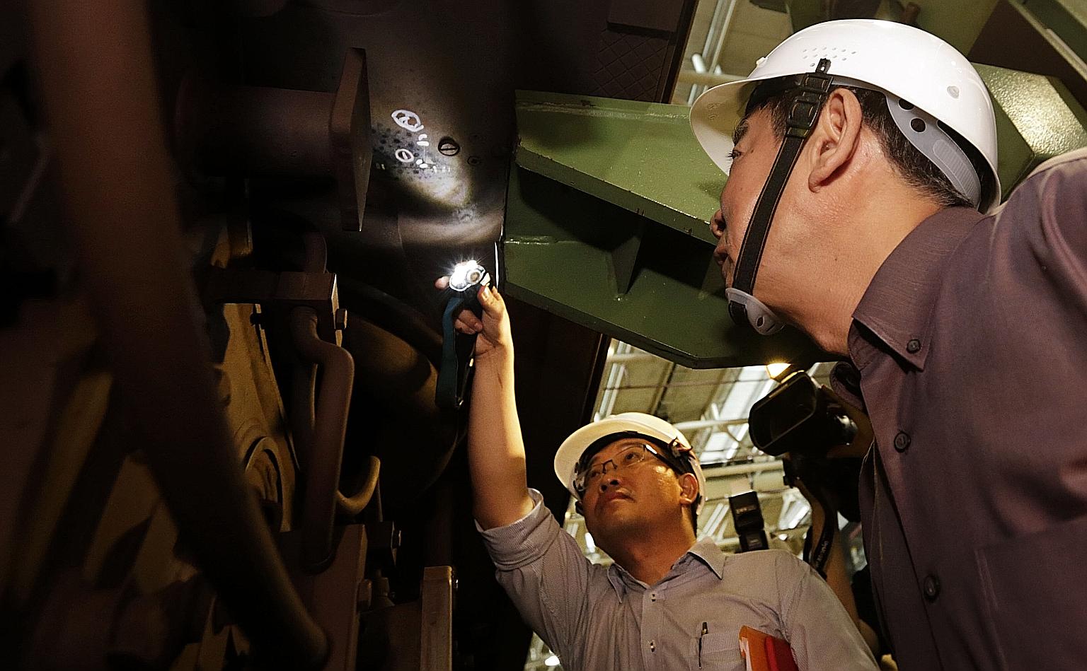 Mr Khaw (at right in picture) on a site visit to the Bishan Depot on July 12 to view one of the affected trains with hairline cracks on the bolster. He said the Kawasaki-Sifang train incident has not affected the reliability of the system, as no trai