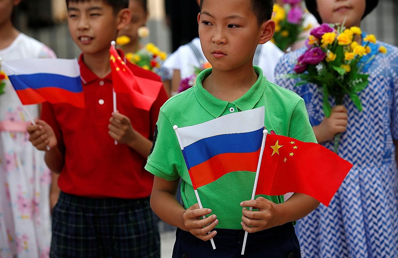 Children with Russian and Chinese flags before a welcoming ceremony for Russian President Vladimir Putin in Beijing in June. Analysts say that rather than a Cold War-style confrontation, what is happening instead is a deepening of the Sino-Russian re