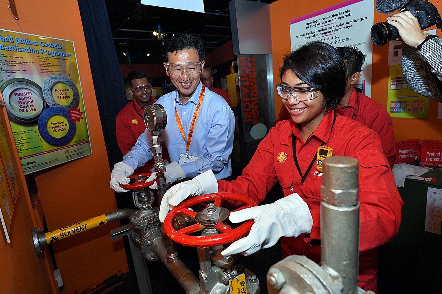 Ms Masyitah showing Mr Ong some skills she picked up under the new SkillsFuture Earn and Learn Programme.