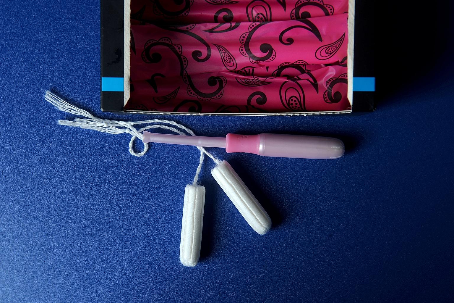 Tampon applicator and tampons on blue background