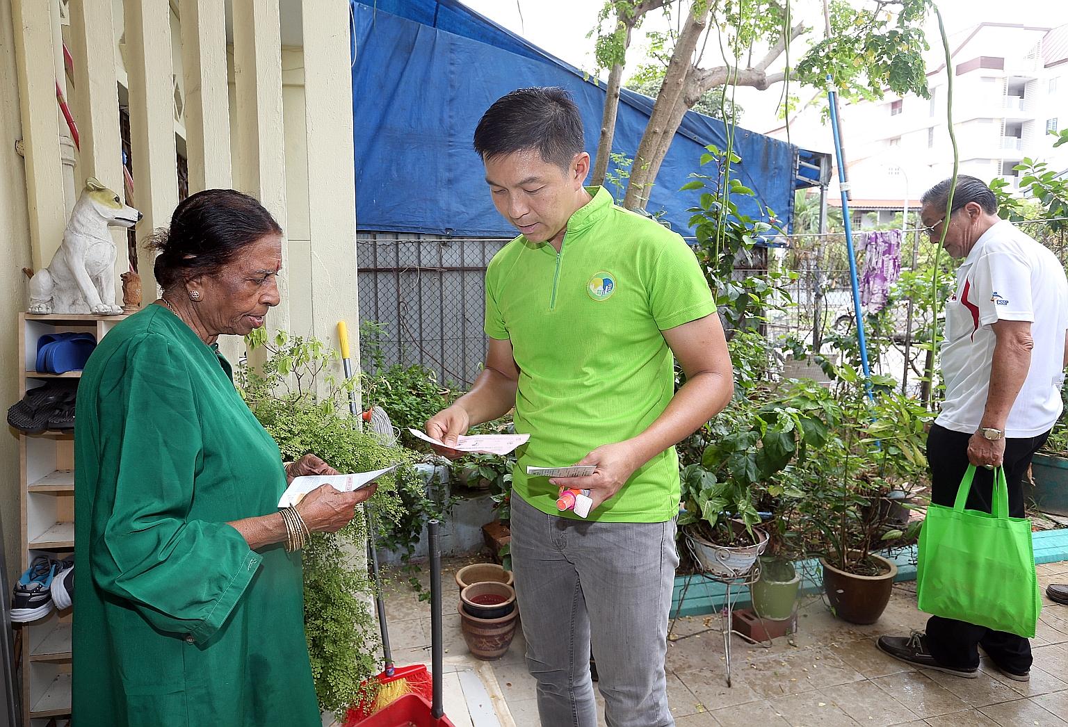 Mr Tan speaking with a resident while visiting homes in Joo Chiat Place and Lorong 101 Changi yesterday.