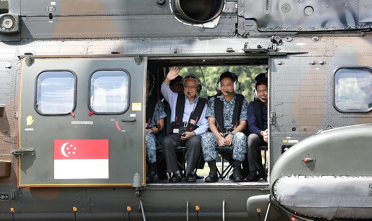 President Tan waving to the media during a ride in the Super Puma during his visit to the RSAF's Sembawang Air Base yesterday.