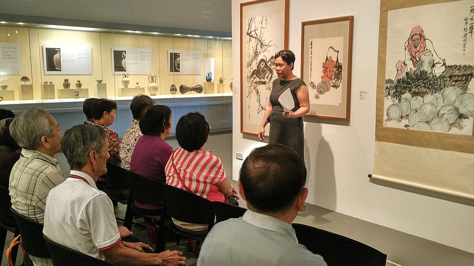 Seniors in an art reminiscence therapy session at NUS Museum. Six volunteer museum guides are trained to understand group dynamics, know how to elicit emotions and use paintings to relate to the seniors' memories and life experiences.