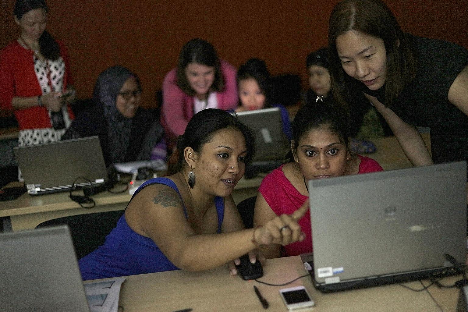 Ms Sarina (far left) and Ms Kavitha Amudhan, 38, learn how to use Excel with the help of volunteer trainer Chan Wai.