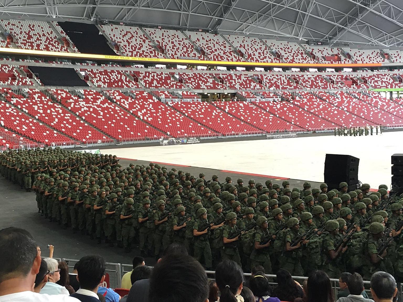 Recruits from the Basic Military Training Centre and the 3rd Battalion of the Singapore Guards at the stadium during their passing-out parade yesterday, watched by family members and friends.