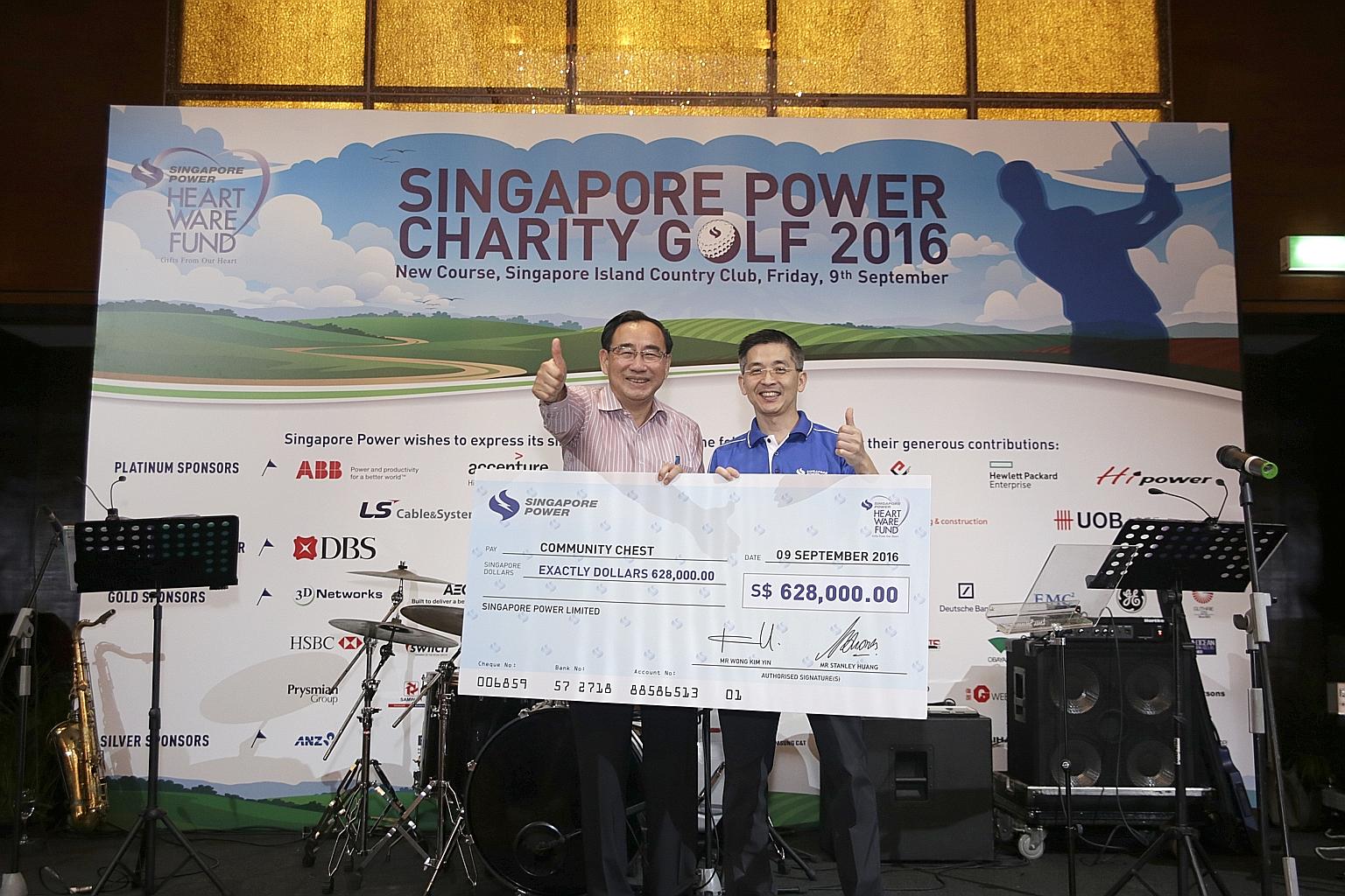 Mr Phillip Tan (far left), chairman of the Community Chest, receiving a cheque from Mr Wong Kim Yin, group chief executive of Singapore Power. The money will go to the Singapore Power Heartware Fund, which supports services for the elderly under the 
