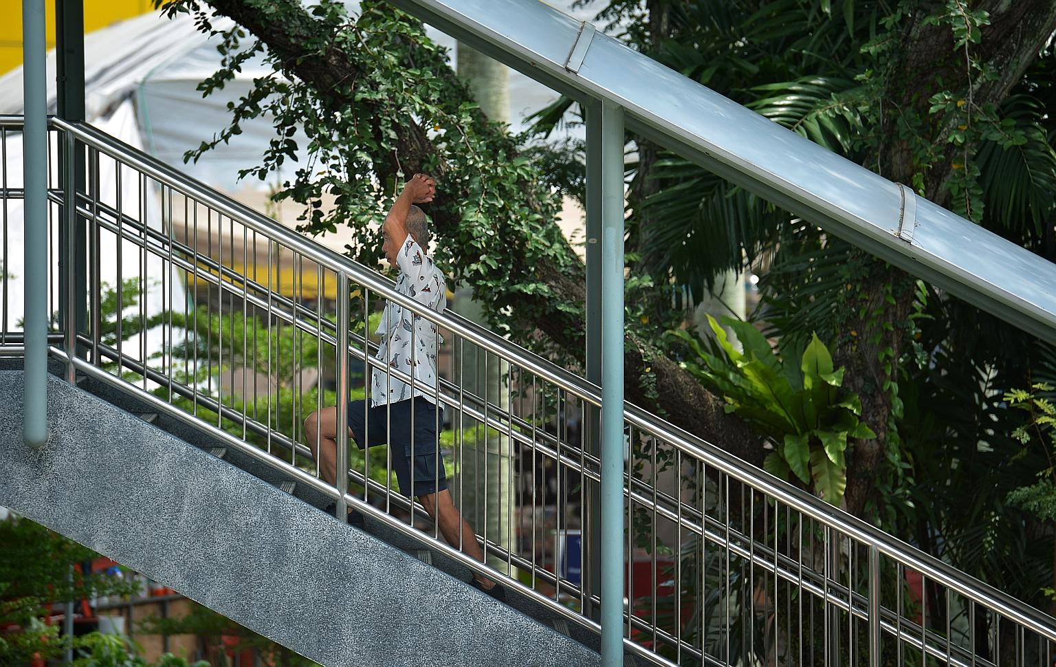 A man doing stretching exercises while walking up an overhead bridge in Toa Payoh Lorong 6 yesterday. With the number of seniors rising even as family support gets weaker, the demand for institutions providing elderly care will grow. However, with se