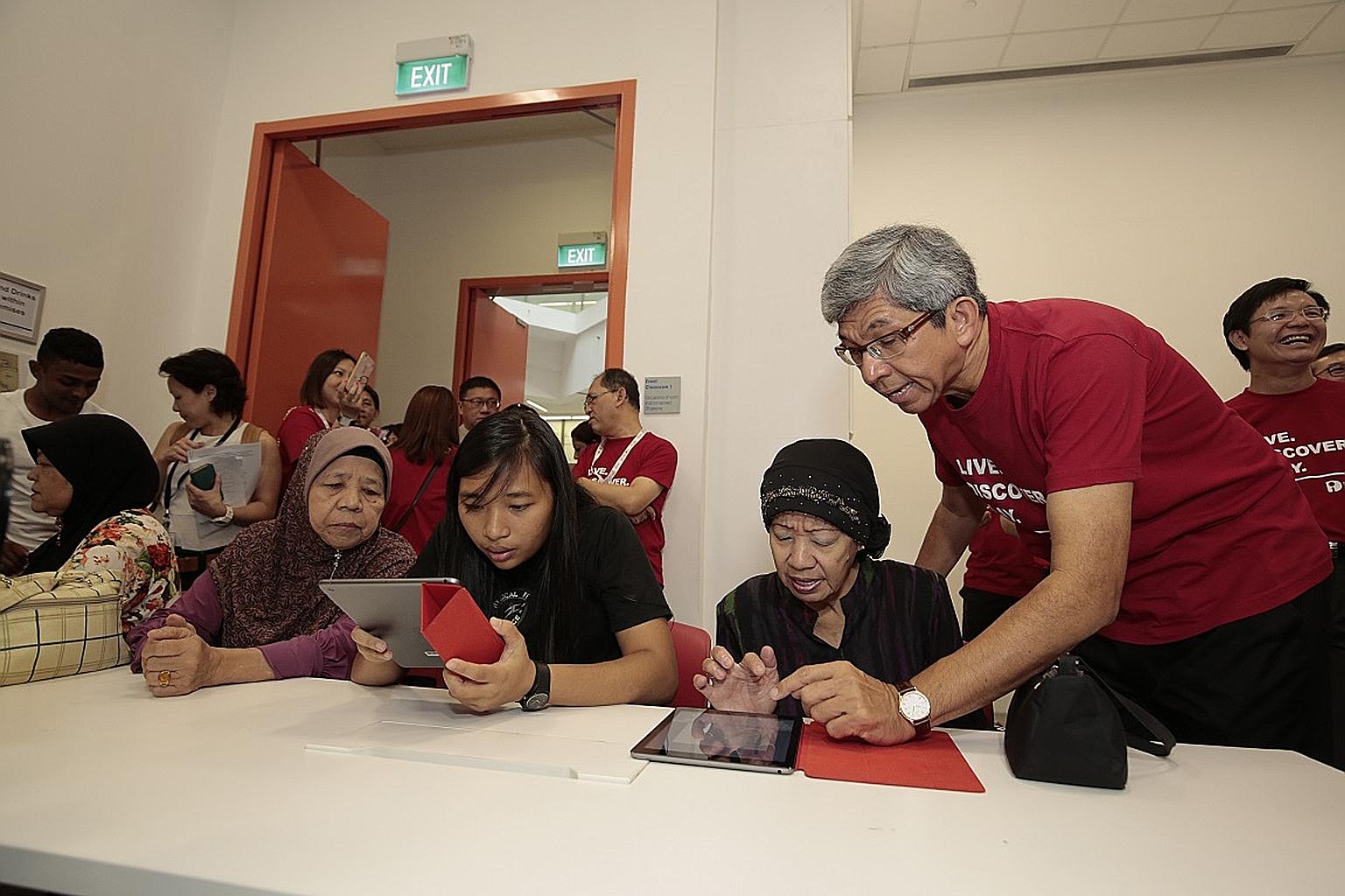 Dr Yaacob (at right) helping a participant use a tablet at an IT workshop conducted in Malay yesterday, during the Silver IT Fest 2016.