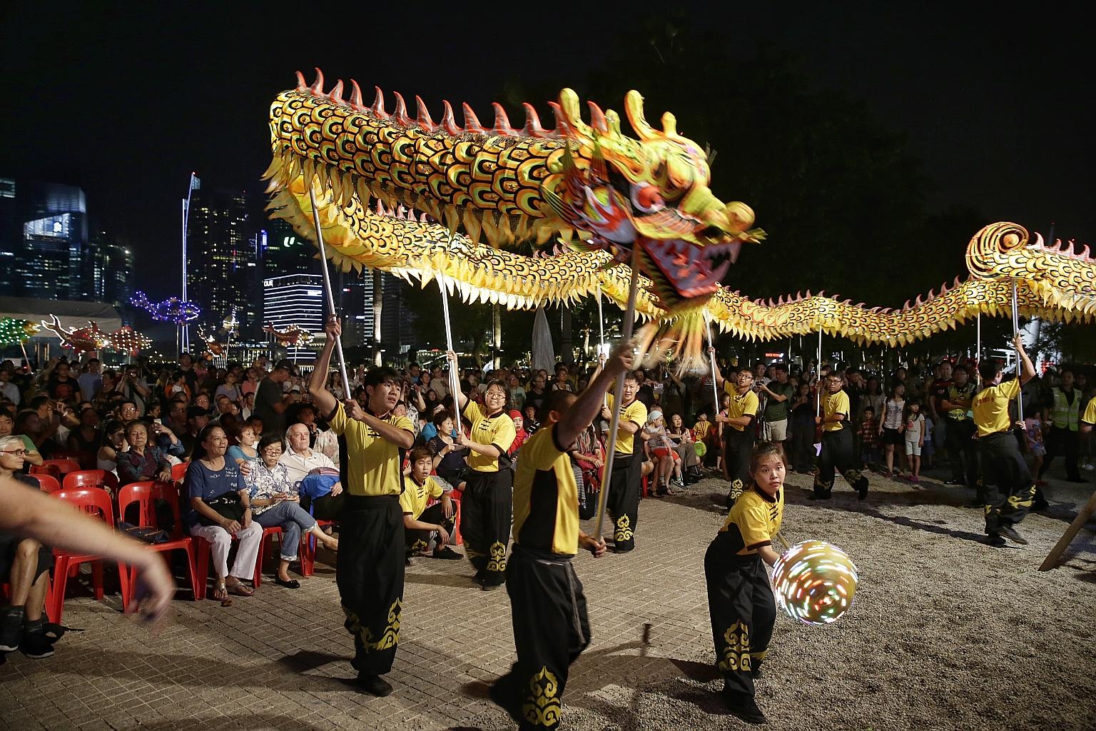 Beneficiaries of voluntary welfare organisations such as Peace-Connect Seniors Activity Centre, the Chinese Development Assistance Council and Transient Workers Count Too enjoying a dragon dance performance by Hong Jie Association at the Esplanade ye