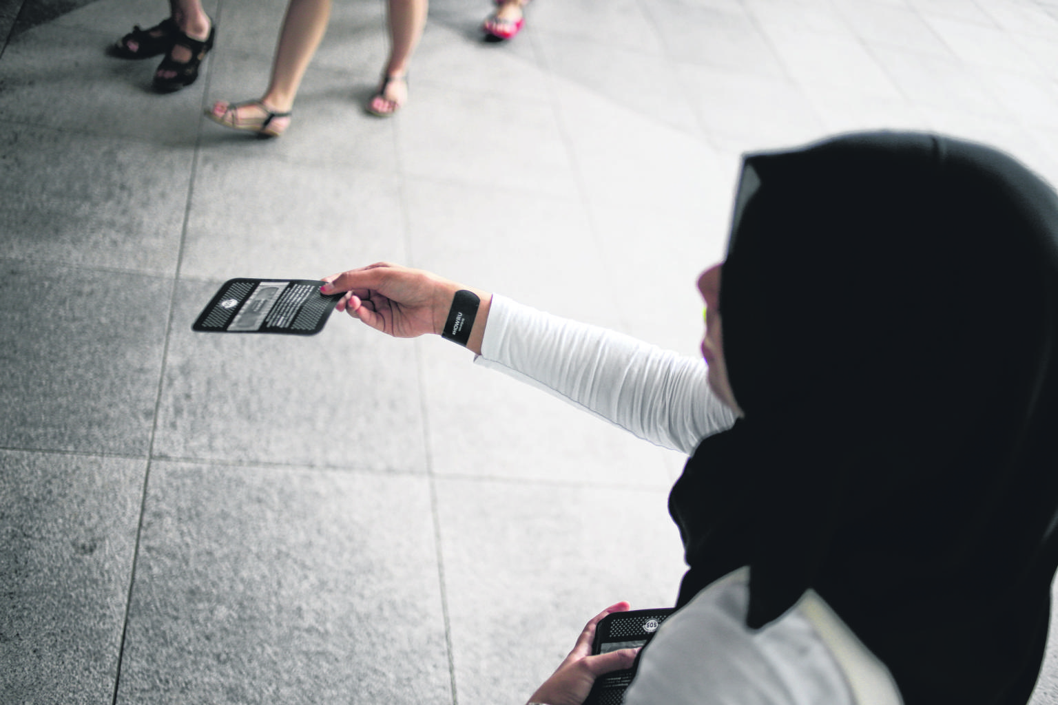 Ms Munirah Abdul Aziz, 21, a student volunteer with Samaritans of Singapore giving out black plasters outside Suntec City yesterday to raise awareness of youth suicide.