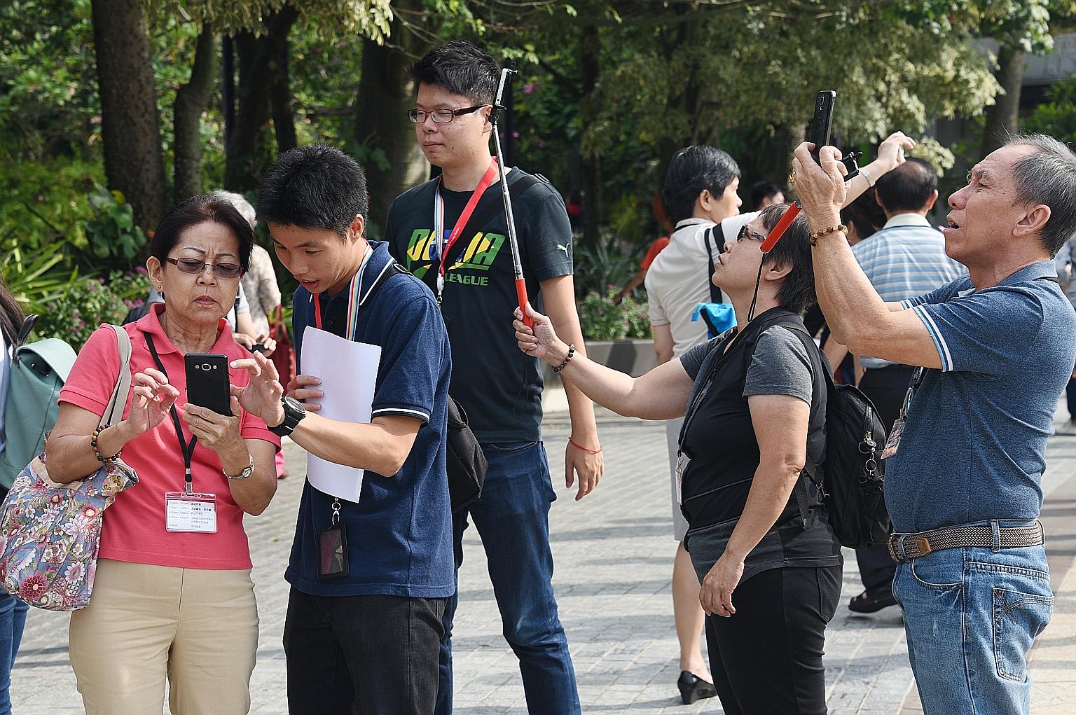 Some seniors getting pointers on how to take selfies and other photos with their smartphones at yesterday's event organised by Singtel and Chinese evening dailies Shin Min Daily News and Lianhe Wanbao.