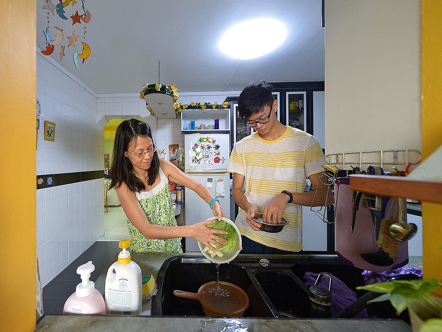 Student Timothy Chan, 16, and his mother Jackie, 46, washing vegetables and rice in their Tampines home. Over the years, there has been some progress in reducing water usage in Singapore homes.