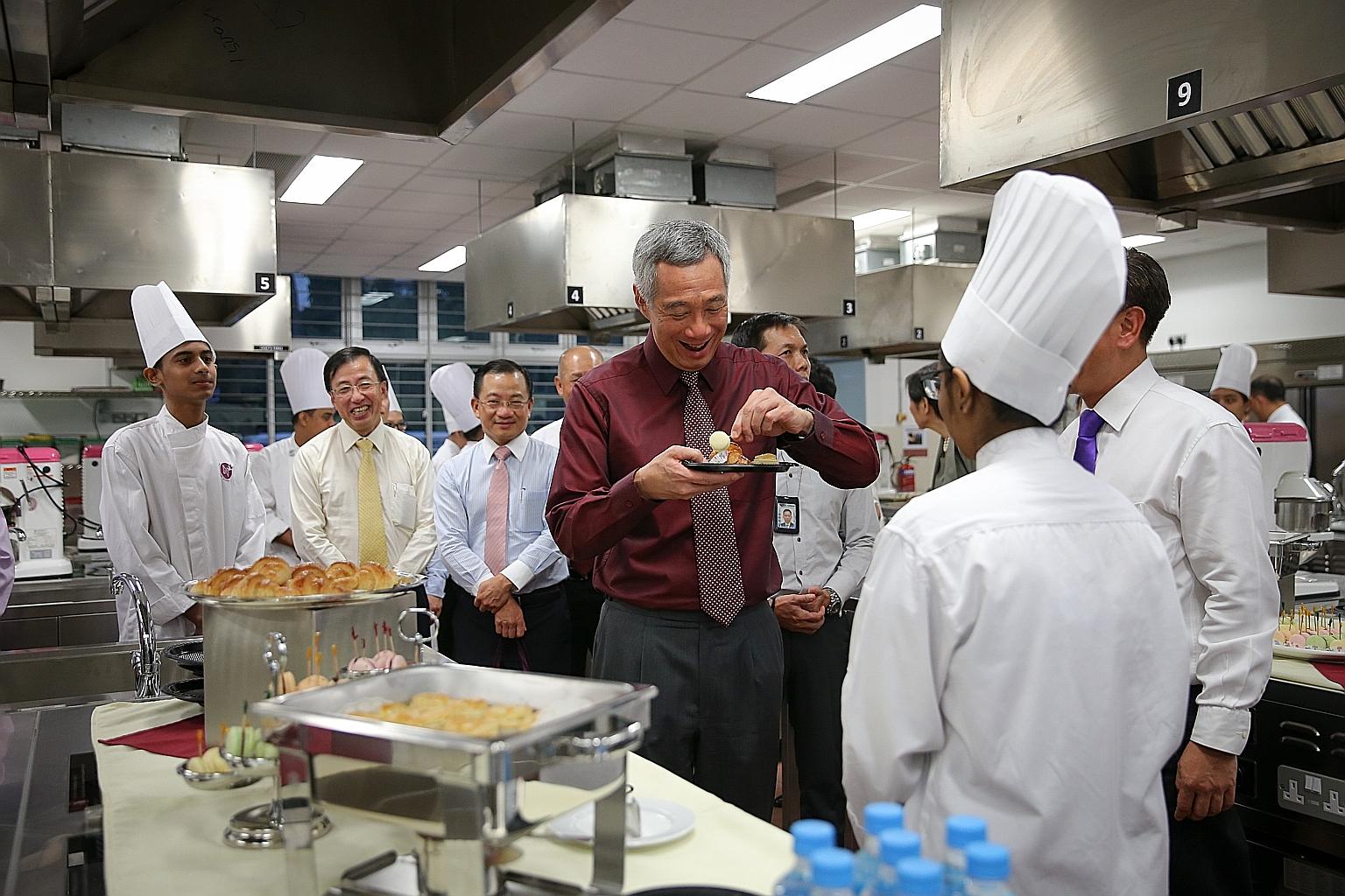 PM Lee sampling pastries made by NorthLight students yesterday. The school has changed not just the lives of its students, but has also influenced Singapore's wider education system, he said.