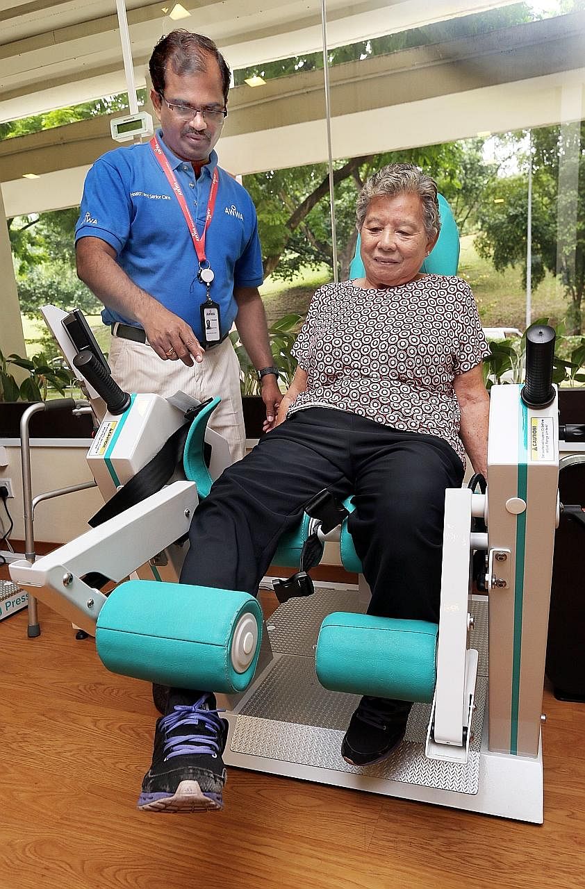 Madam Ooi using a Gym Tonic machine with help from senior occupational therapist P. Pandiarajan. She no longer suffers knee pain and can go to the wet market by herself.