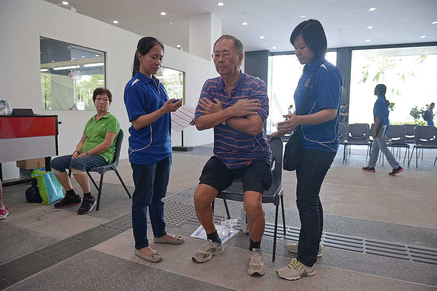 Mr Lim taking the fitness test yesterday at Pasir Ris Sports Complex while his wife, Madam Tan Sai Choo (left), looks on.