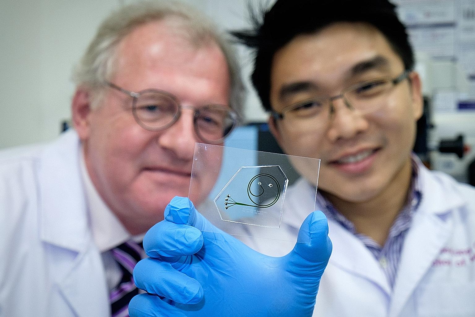 Prof Boehm and Dr Hou with the quick test kit. It contains a chip which extracts white blood cells from a patient's blood sample, and an analyser which doctors can use to observe the cells' movement and function. This helps them to conclude whether t