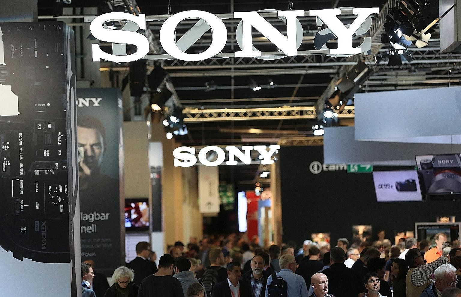 Visitors browsing a display containing a selection of Canon camera lenses during the Photokina photography trade fair in Cologne on Sept 20. At the Photokina photography trade fair, Sony unveiled&#97; the the &#97;99 II, the long-awaited successor to