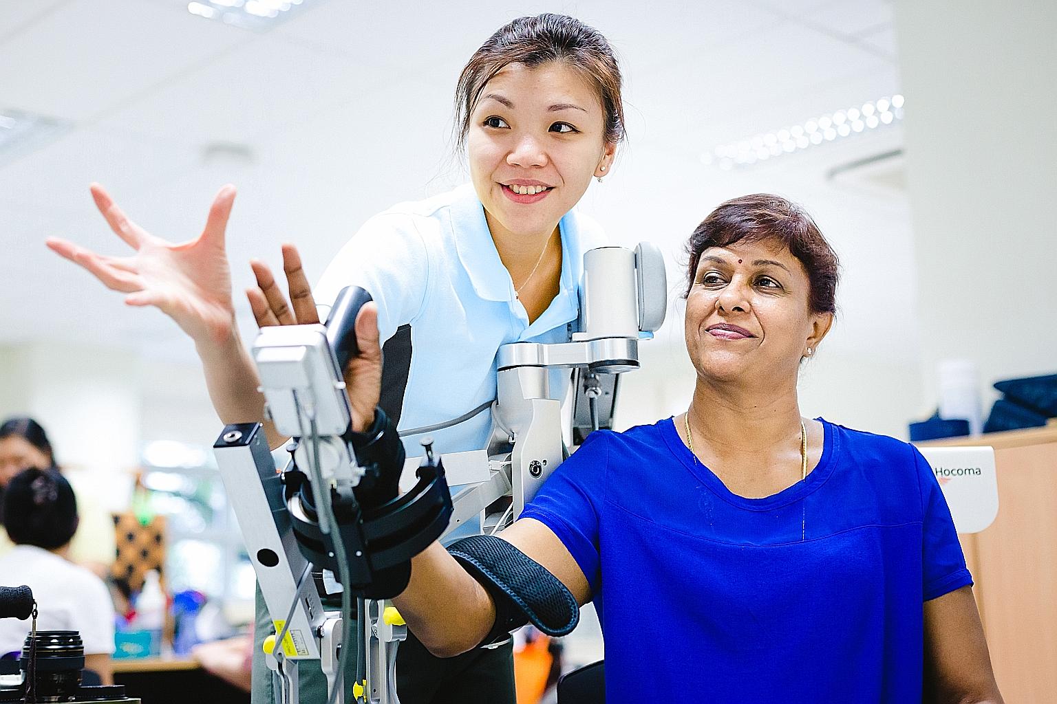St Luke's Hospital's occupational therapist Charissa Tan using the Armeo Spring to help a patient during therapy.