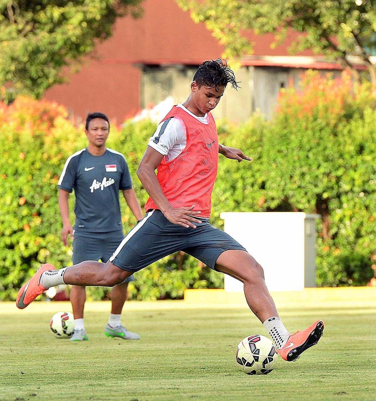 Irfan Fandi shaping to shoot during his first training session with the senior national team in March as his father Fandi Ahmad watches on at the Geylang Field. The 19-year-old may receive his first senior cap against Malaysia next week.