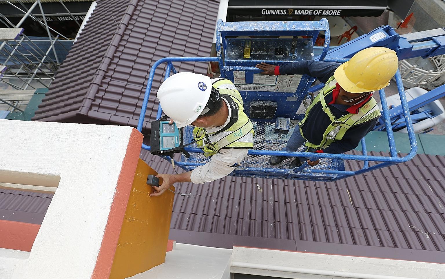 Above: The concrete sunshade on the fourth floor of Block 201E, Tampines Street 23, which broke off on Sunday and landed partly on another sunshade directly below it. Right: A tester from a laboratory engaged by HDB inspecting a sunshade at the Tampi