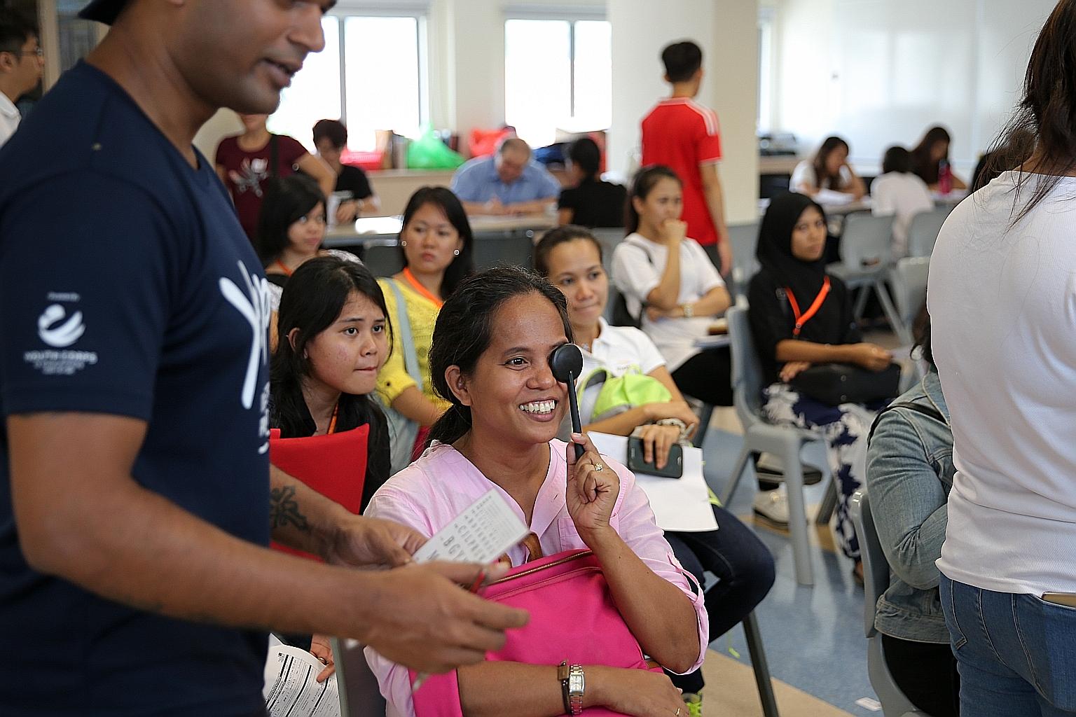 Foreign domestic helpers getting their eyes checked at the United World College of South East Asia campus in Dover Road yesterday.